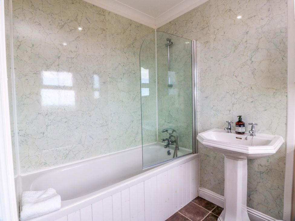 A bathroom with a bathtub and a pedestal sink at Little Laight in Cairnryan near Stranraer