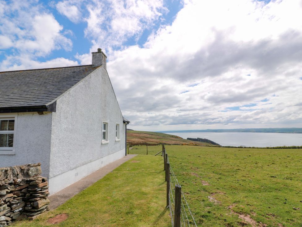 A house with grass and a view of water at Little Laight Cairnryan near Stranraer