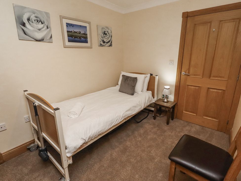 A bedroom with a bed and a side table at Long Cart Cottage in Embleton