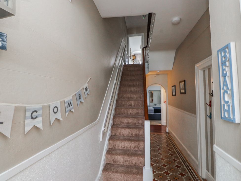 A hallway with a staircase and decorative banner at The View in Criccieth