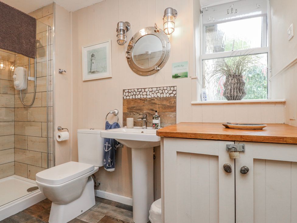 A bathroom with a shower, sink, and toilet at The View in Criccieth