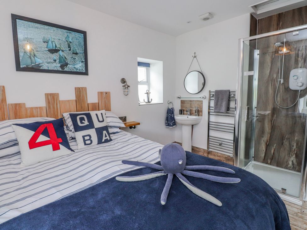 A bedroom with a bed, mirror, and shower at The View in Criccieth