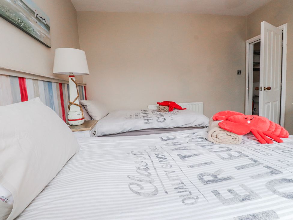 A bedroom with two beds and a lamp at The View in Criccieth