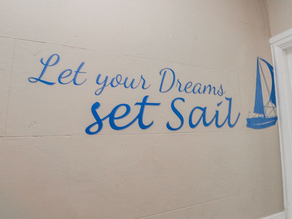 A wall with a sailing quote and illustration at The View in Criccieth