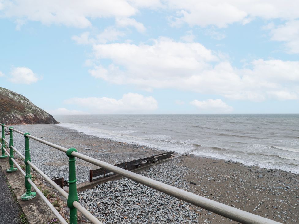 A beach with pebbles and sea under a cloudy sky at The View in Criccieth