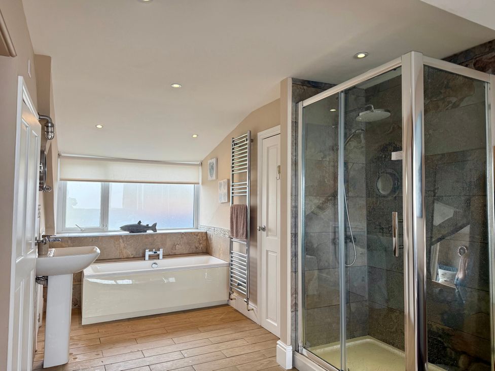 A bathroom with a bathtub and shower at The View in Criccieth