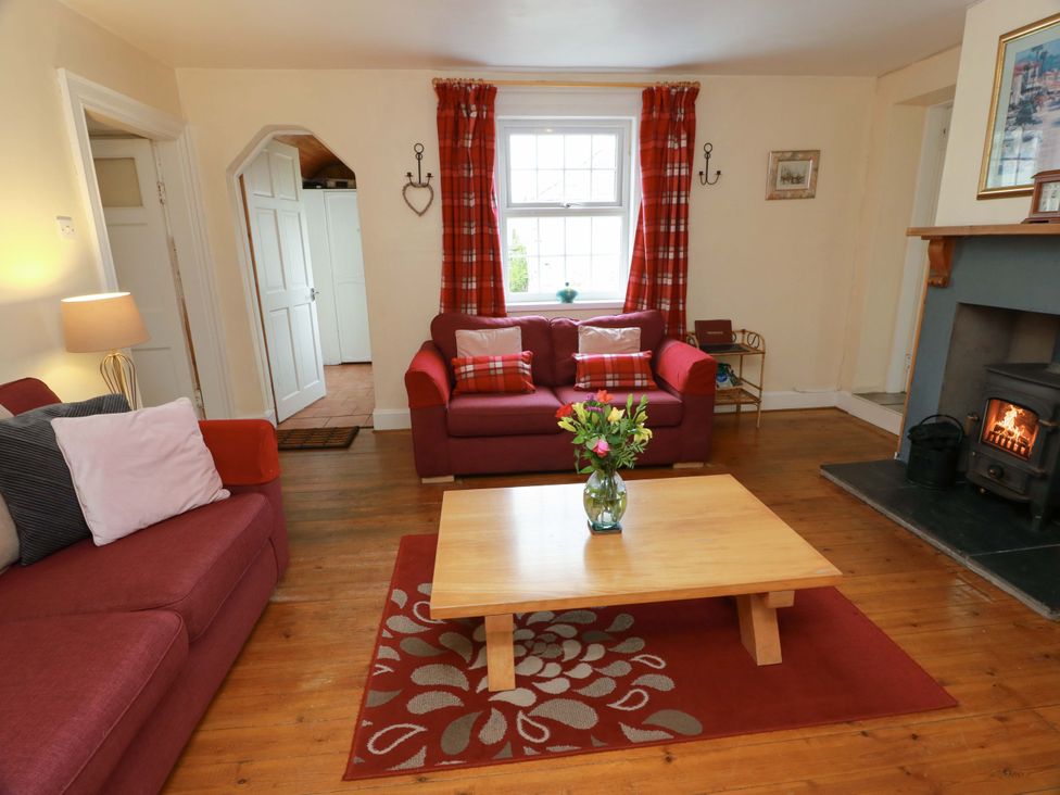 A living room with a coffee table and a fireplace at Camphill in Kirkcudbright
