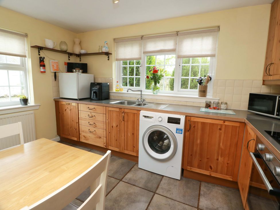 A kitchen with a washing machine and sink at Camphill in Kirkcudbright