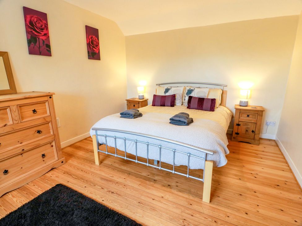 A bedroom with a bed and dresser at Camphill in Kirkcudbright