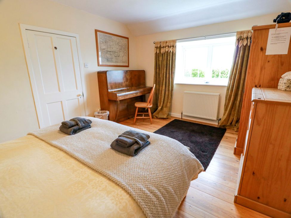A bedroom with a bed and piano at Camphill in Kirkcudbright