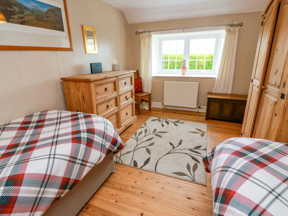 A bedroom with two beds and a dresser at Camphill in Kirkcudbright