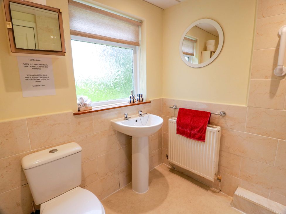 A bathroom with a sink, toilet, and radiator at Camphill, Kirkcudbright