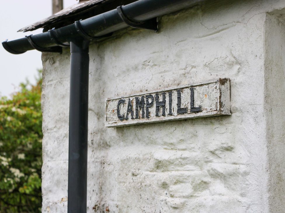 A sign on a stone wall at Camphill in Kirkcudbright