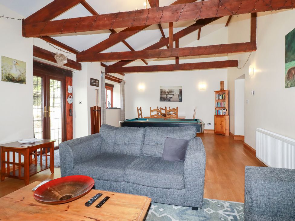 A living room with a sofa and coffee table at Kingfisher Barn in East Taphouse