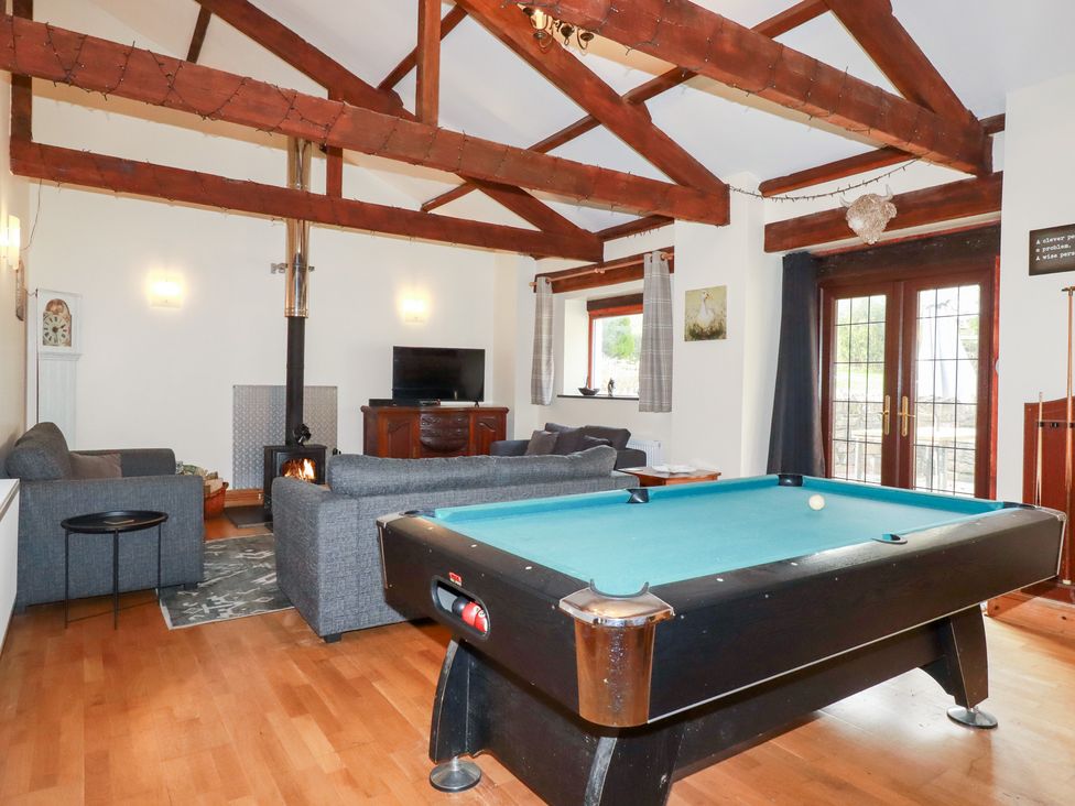 A living room with a pool table and sofa at Kingfisher Barn in East Taphouse