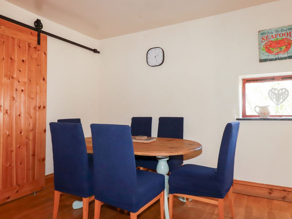 A dining room with a table and chairs at Kingfisher Barn East Taphouse