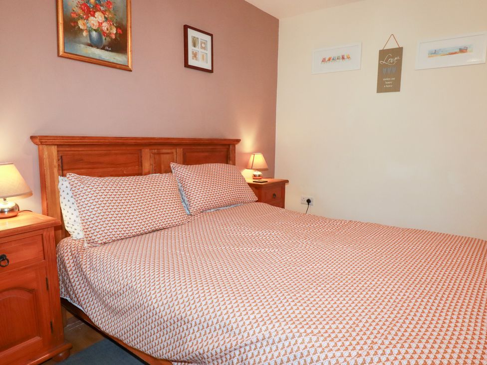 A bedroom with a bed and bedside tables at Kingfisher Barn East Taphouse