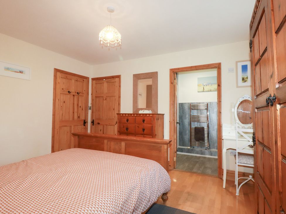A bedroom with a bed and dresser at Kingfisher Barn in East Taphouse