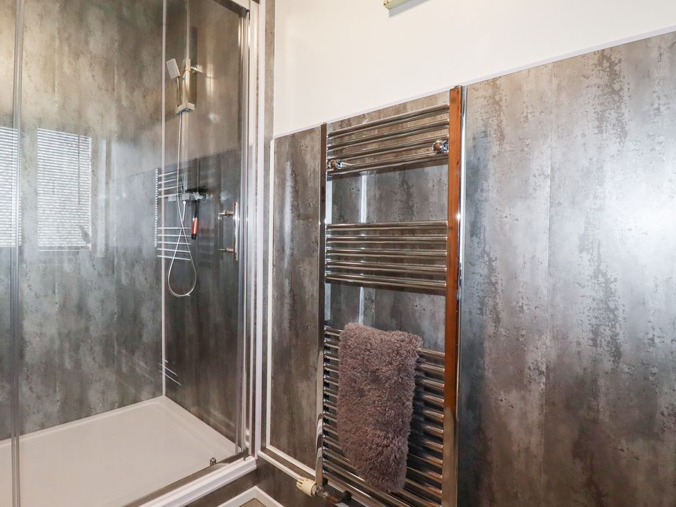 A bathroom with a shower and towel radiator at Kingfisher Barn East Taphouse