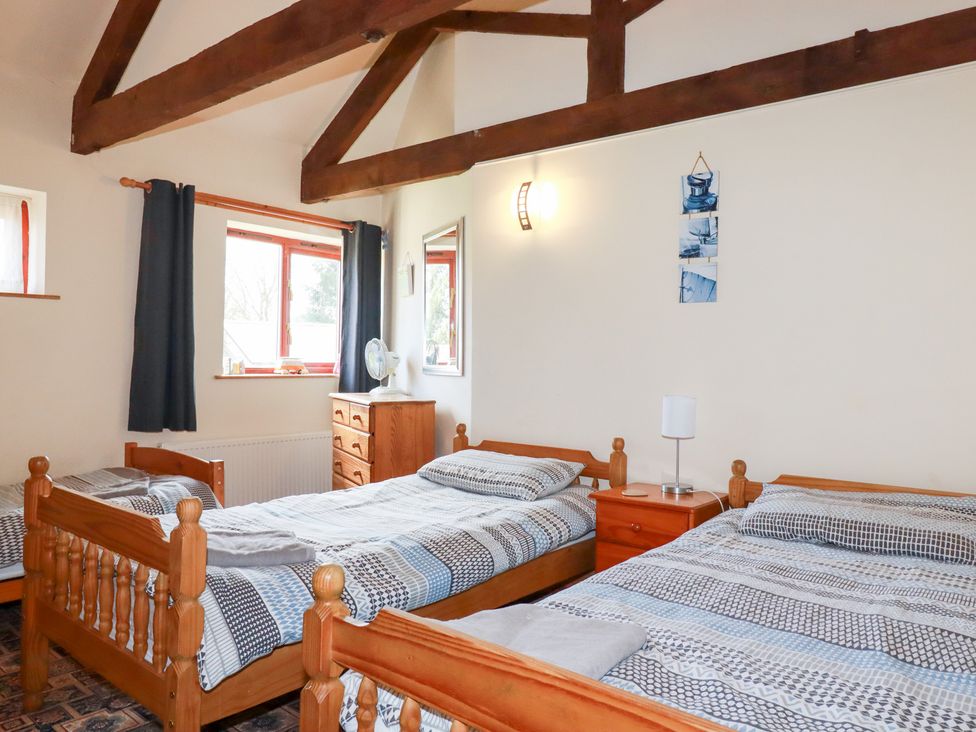 A bedroom with two beds and furniture at Kingfisher Barn in East Taphouse