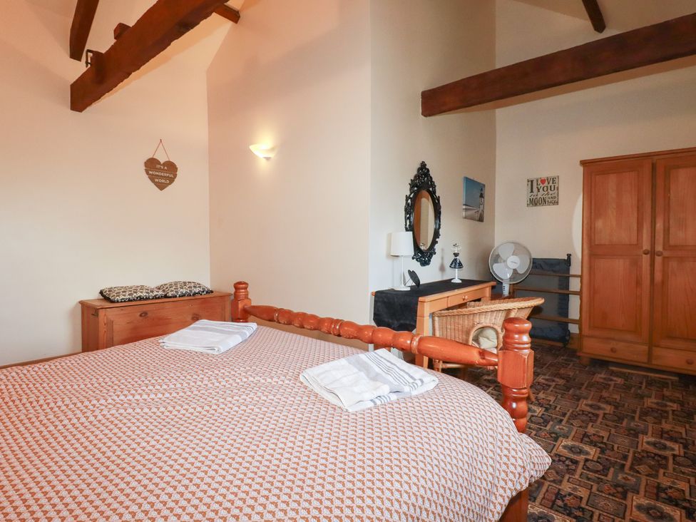 A bedroom with a bed and wardrobe at Kingfisher Barn in East Taphouse