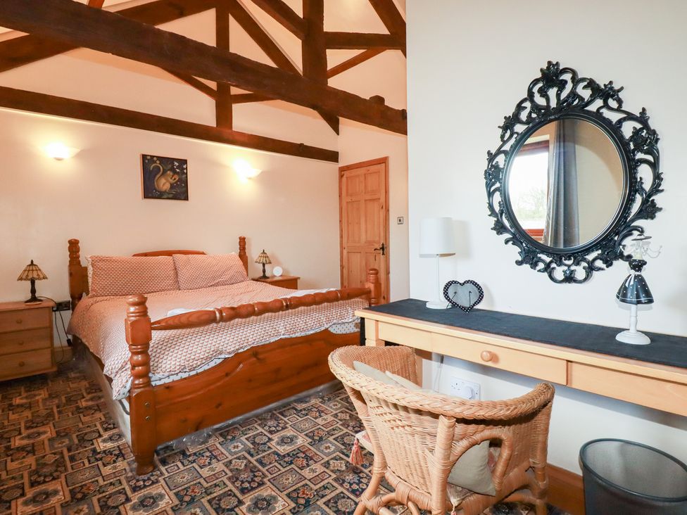 A bedroom with a bed and desk at Kingfisher Barn in East Taphouse