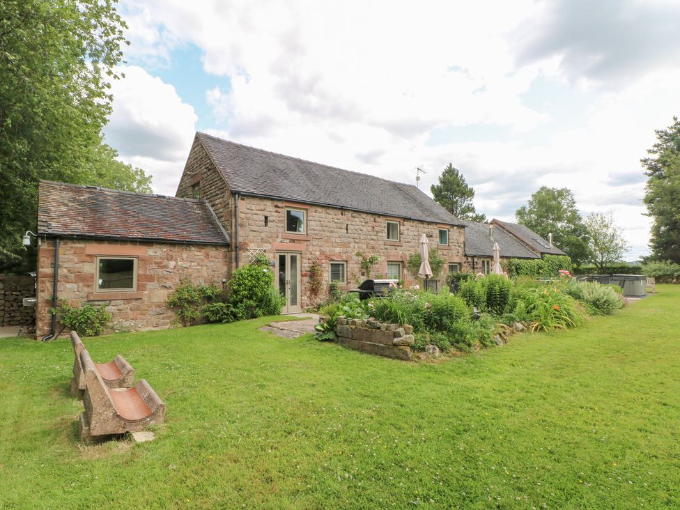 A garden view of a stone house at Lee House Cottage in Cheddleton
