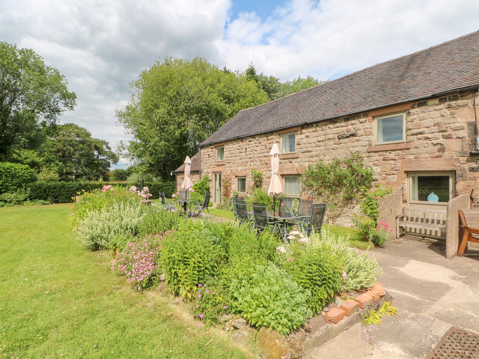 An outdoor area with a stone house and garden at Lee House Cottage in Cheddleton