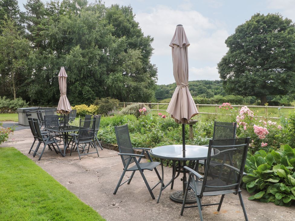 An outdoor seating area with tables and chairs at Lee House Cottage Cheddleton