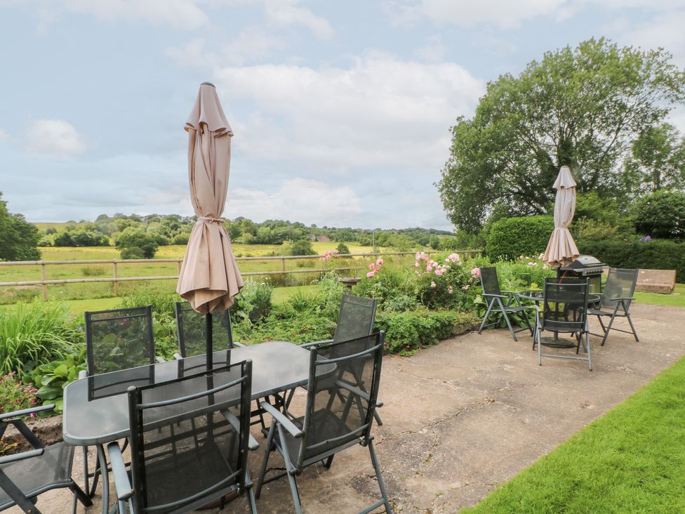 A garden with tables and chairs at Lee House Cottage in Cheddleton