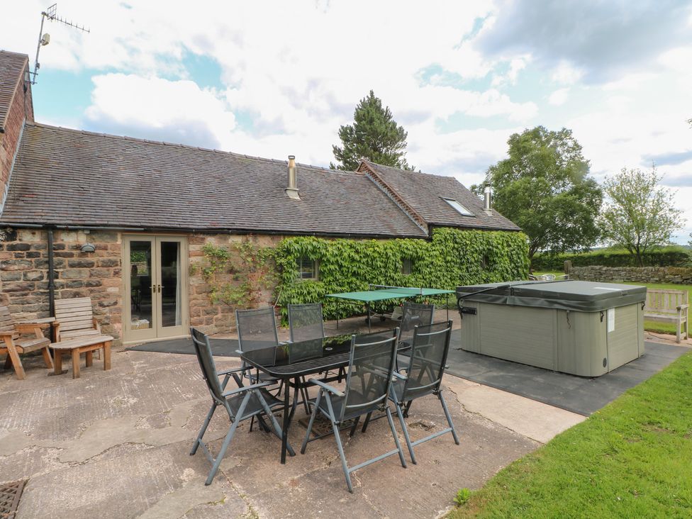 An outdoor patio with a table and chairs at Lee House Cottage Cheddleton
