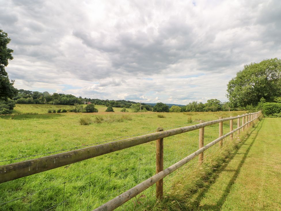 An outdoor field with a wooden fence at Lee House Cottage Cheddleton