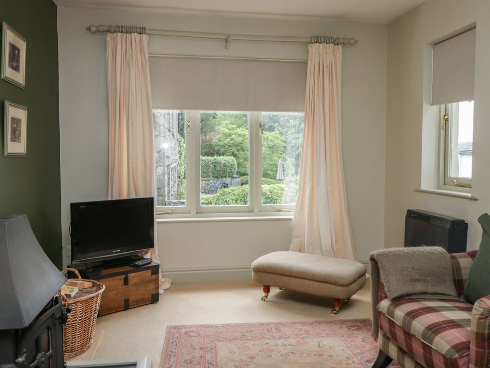 A living room with a television and an ottoman at Gable End in Coniston near Hawkshead