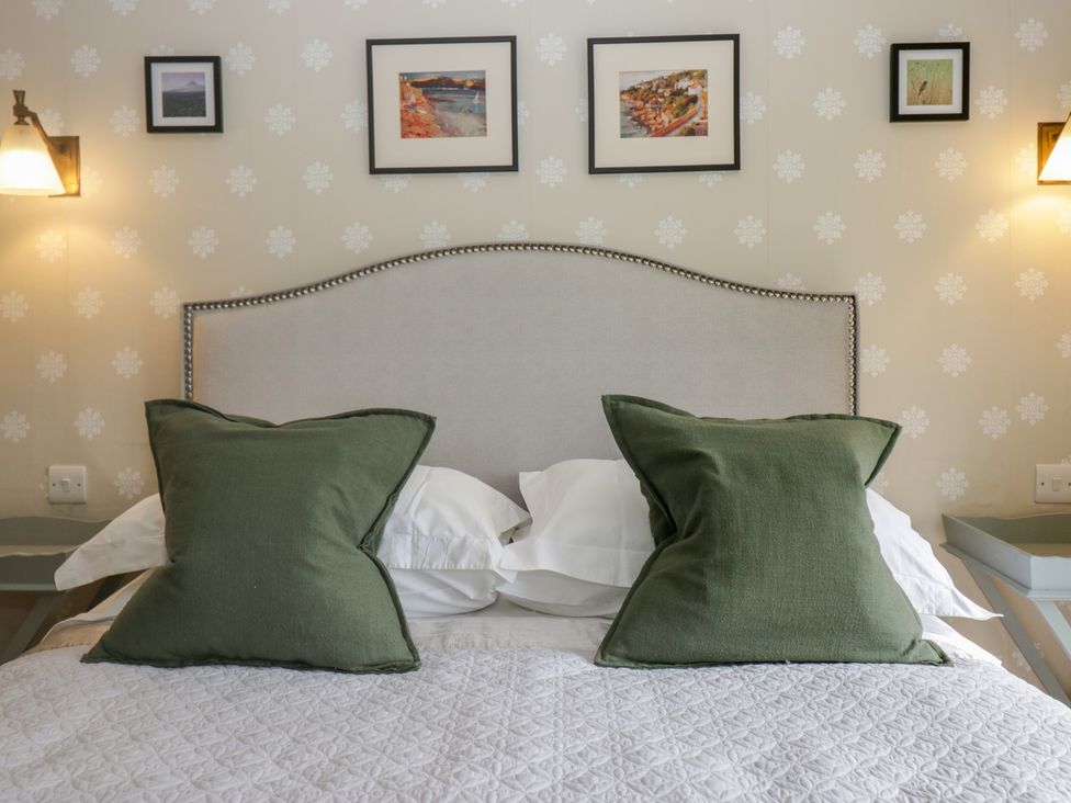 A bedroom with a bed and framed pictures at Gable End in Coniston near Hawkshead