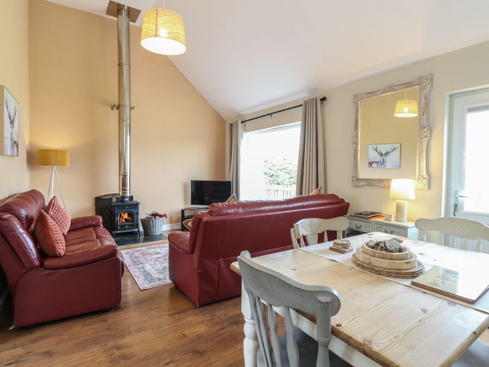 A living room with a sofa and dining table at Sunset Cottage in Craignure, Isle Of Mull