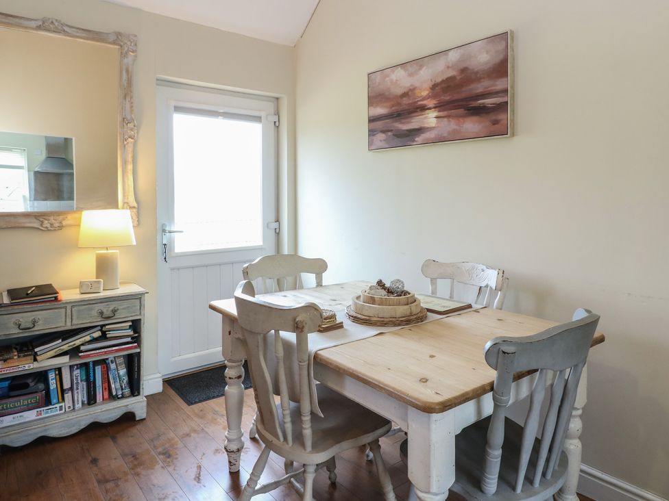 A dining room with a table and chairs at Sunset Cottage in Craignure, Isle Of Mull