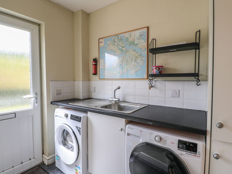 A laundry room with a sink and appliances at Sunset Cottage in Craignure, Isle Of Mull