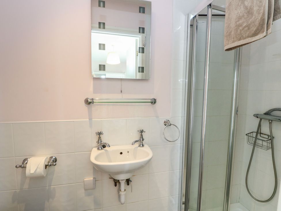 A bathroom with a wash basin and shower at Sunset Cottage, Craignure, Isle Of Mull