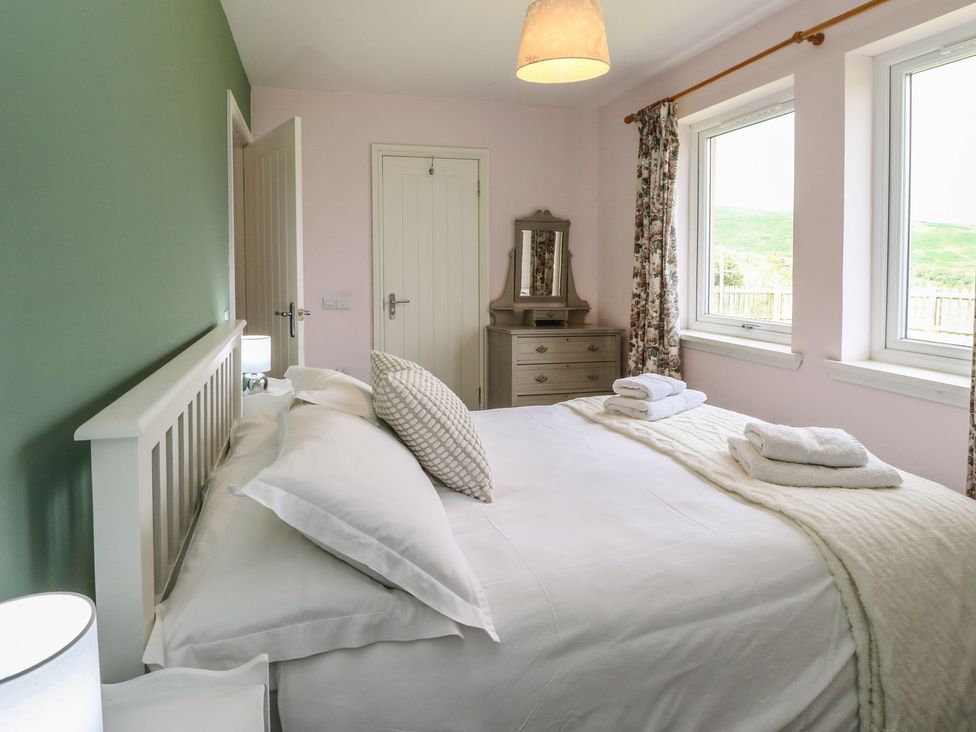 A bedroom with a bed and dresser at Sunset Cottage Craignure, Isle Of Mull