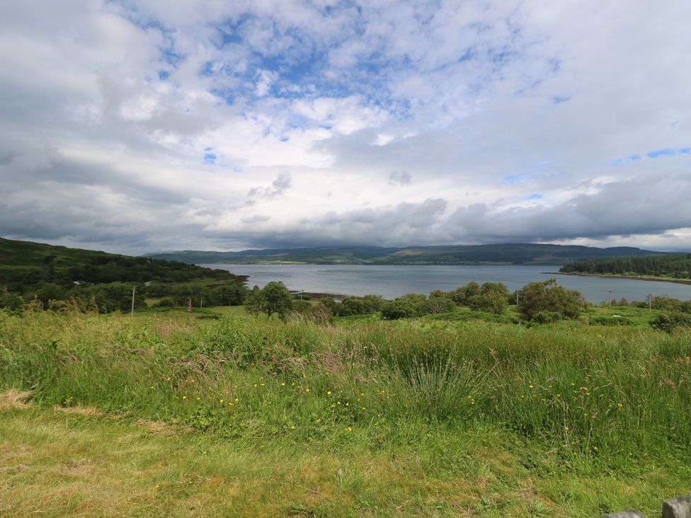 A view of a lake surrounded by grassy areas and trees at Sunset Cottage in Craignure, Isle Of Mull