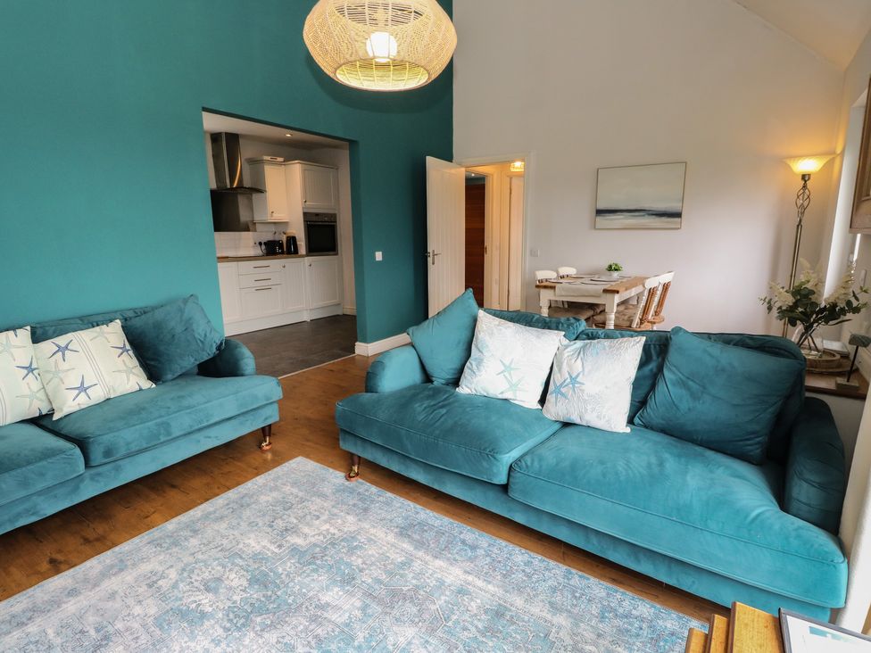 A living room with sofas and a dining area at Starfish Cottage Craignure, Isle Of Mull