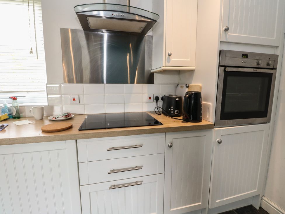 A kitchen with a cooker, kettle, toaster, and oven at Starfish Cottage, Craignure, Isle Of Mull