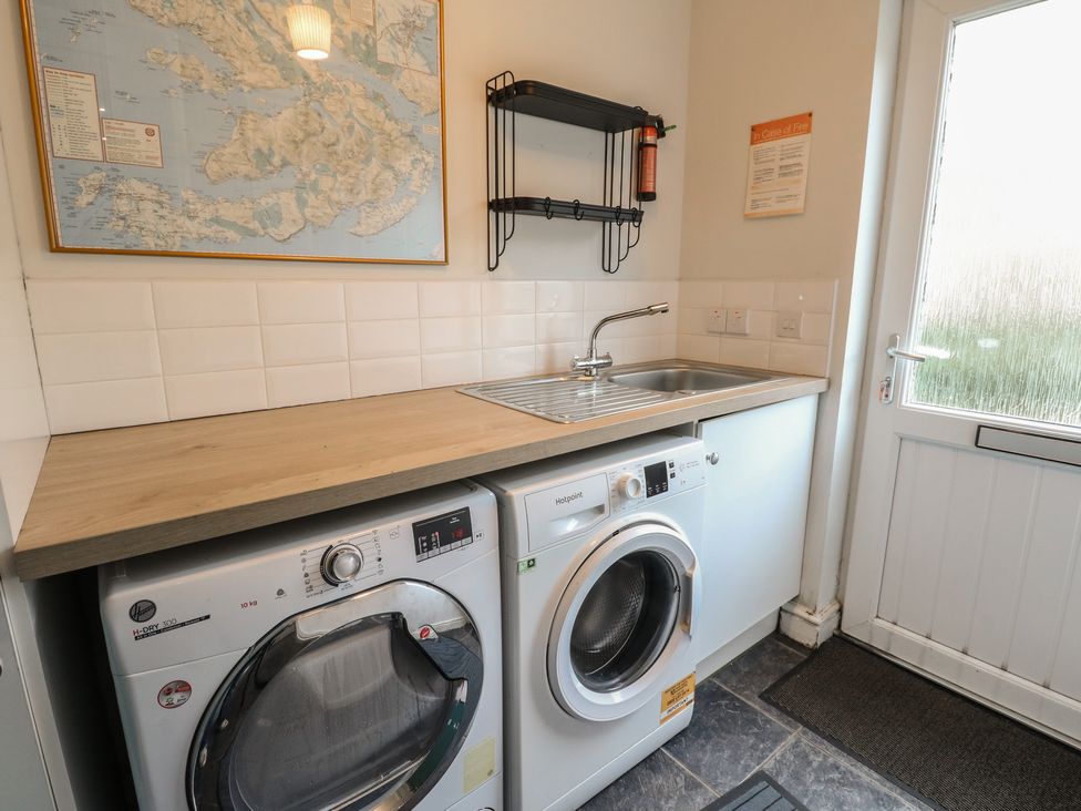 A laundry room with a washing machine and a sink at Starfish Cottage Craignure, Isle Of Mull