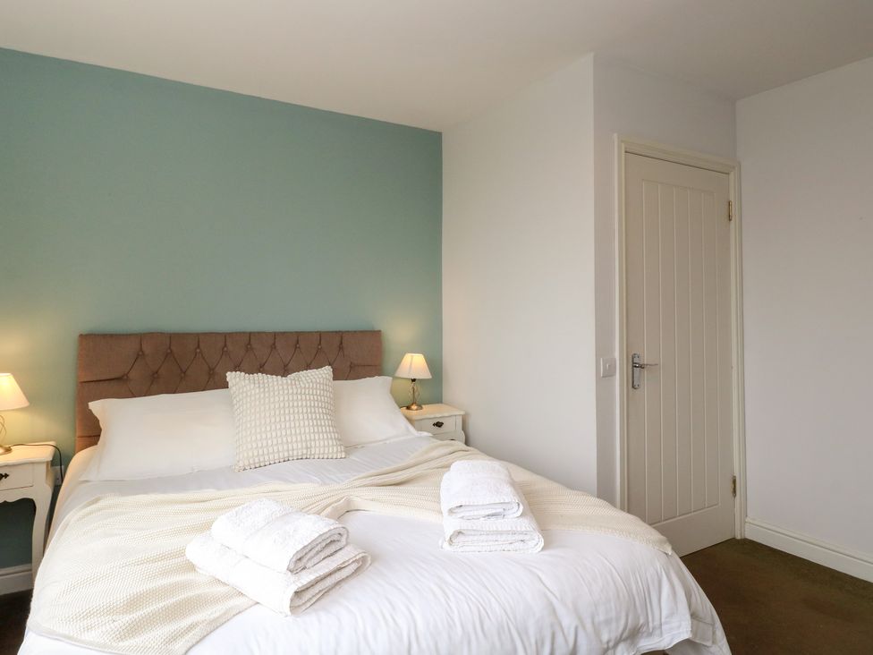 A bedroom with a bed and bedside tables at Starfish Cottage Craignure, Isle Of Mull