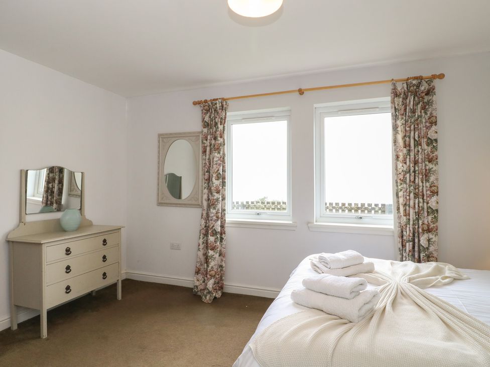 A bedroom with a bed and dresser at Starfish Cottage, Craignure, Isle Of Mull