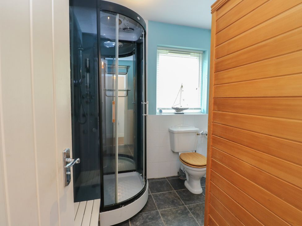 A bathroom with a shower and toilet at Starfish Cottage, Craignure, Isle Of Mull
