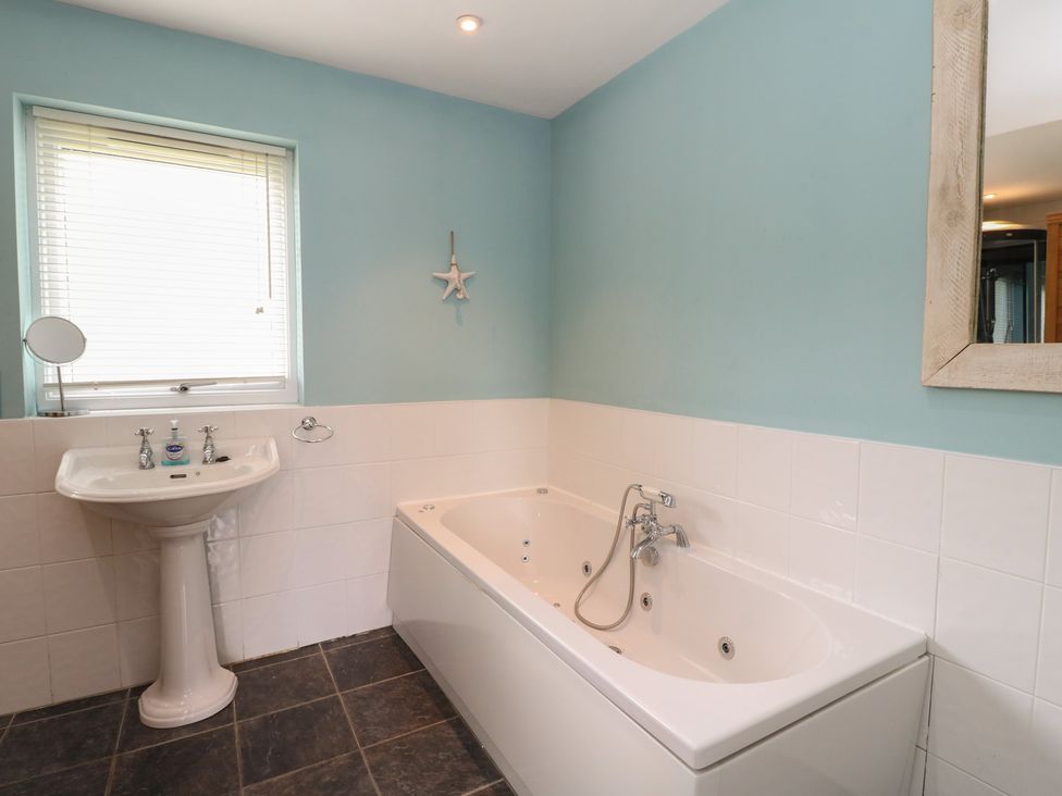 A bathroom with a sink and bath tub at Starfish Cottage, Craignure, Isle Of Mull