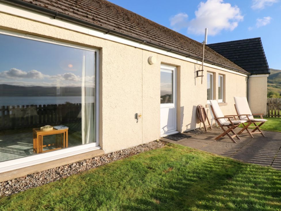 An outdoor area with chairs and a table at Starfish Cottage, Craignure, Isle Of Mull
