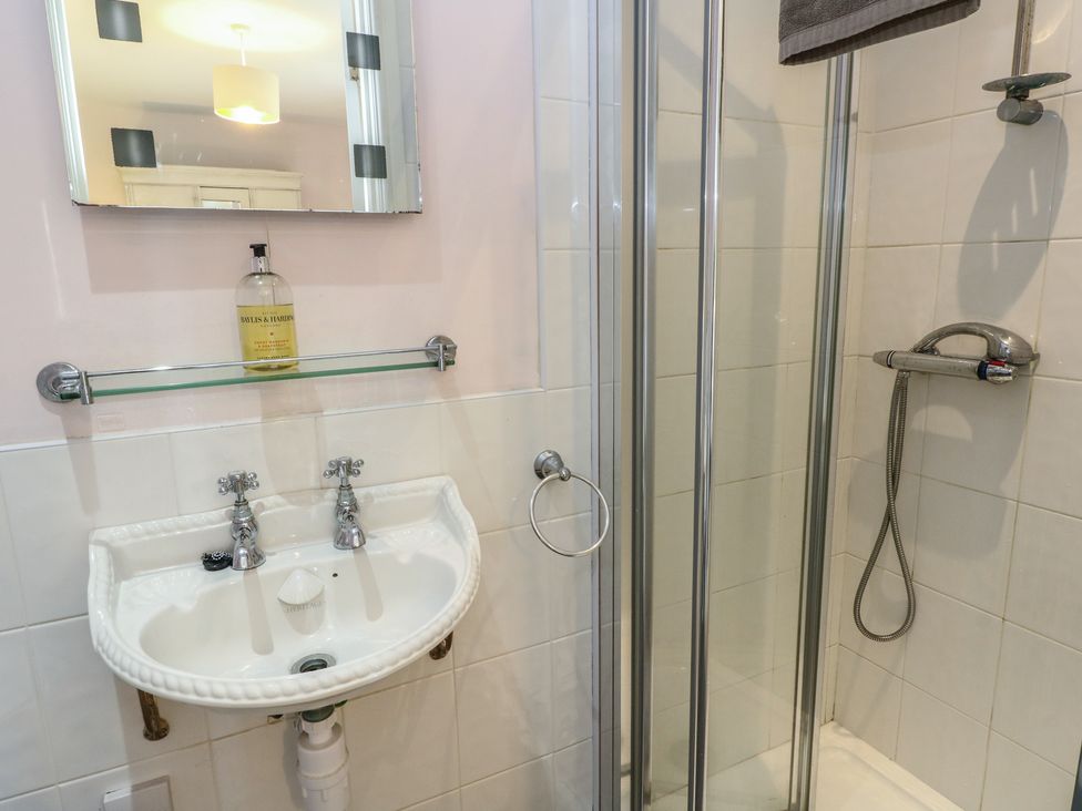 A bathroom with a washbasin and shower at Driftwood Cottage, Craignure, Isle Of Mull