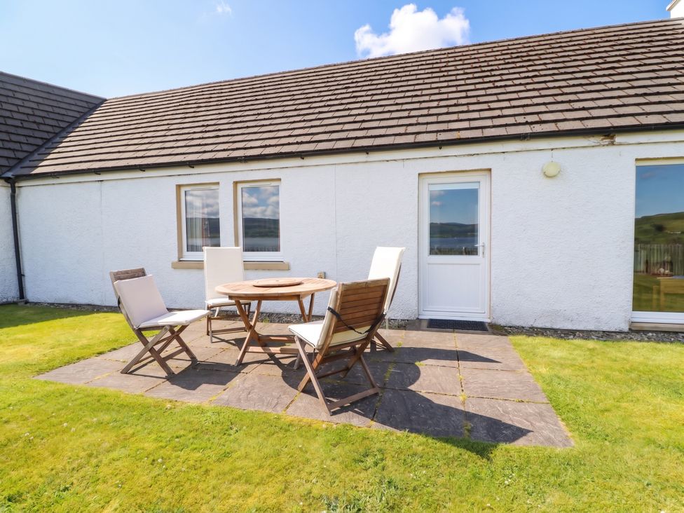 A patio with a table and chairs at Driftwood Cottage, Craignure, Isle Of Mull